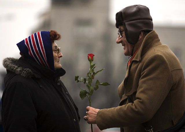 A man offers a rose to a woman to mark International Women's Day in Belgrade